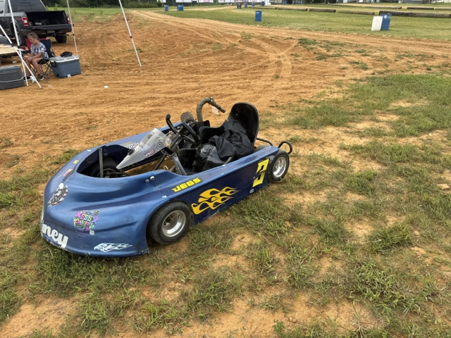 Ronnie's blue 3 kart parked on the grass in the pit area