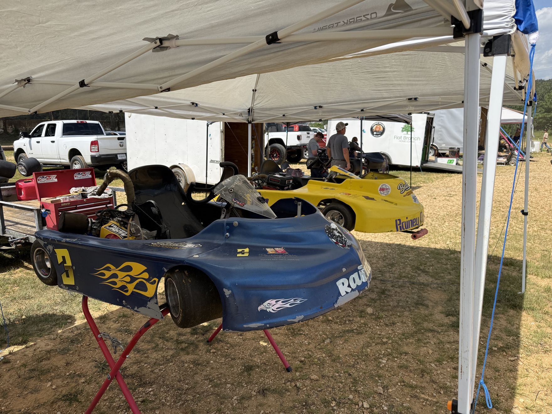 Ronnie's blue 3 and Travis's yellow 10X under the team canopy in the Camden Speedway pits