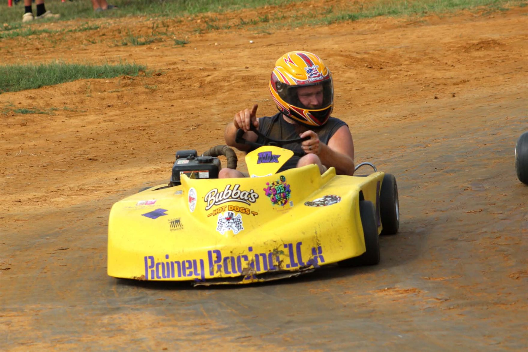 Travis driving the yellow 10X head-on down the dirt at Camden Speedway