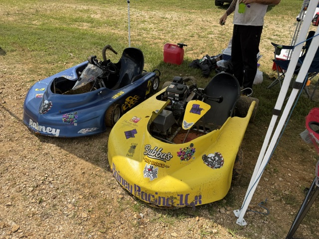 Both Rainey Racing karts sitting in the grass pits between races